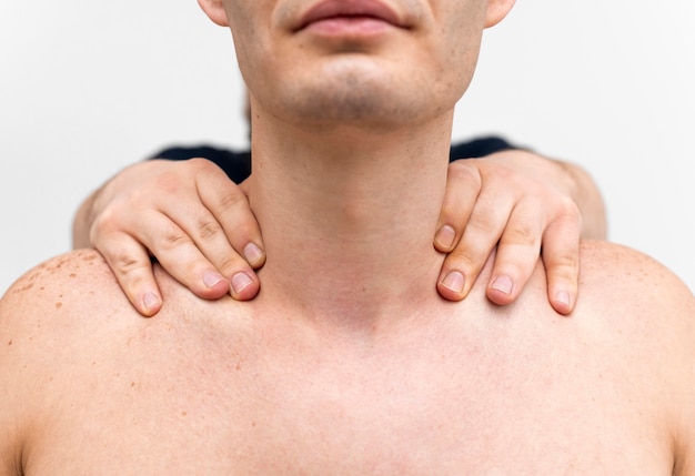 Foto gratuita fisioterapeuta masajeando el cuello del hombre.