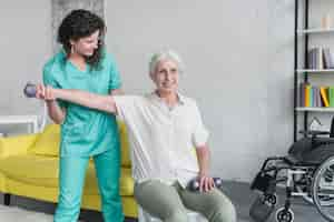 Foto gratuita fisioterapeuta que trabaja con un paciente anciano en una clínica moderna