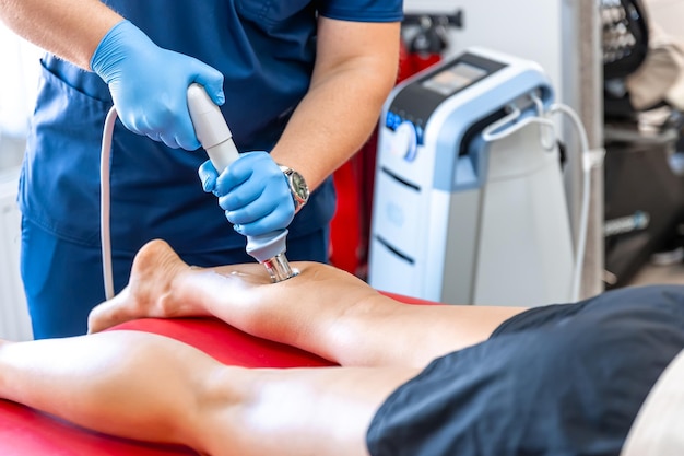 Foto gratuita fisioterapia de la espinilla con ondas de choque terapia extracorpórea con ondas de shock