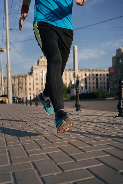 Fit hombre corriendo piernas en la ciudad