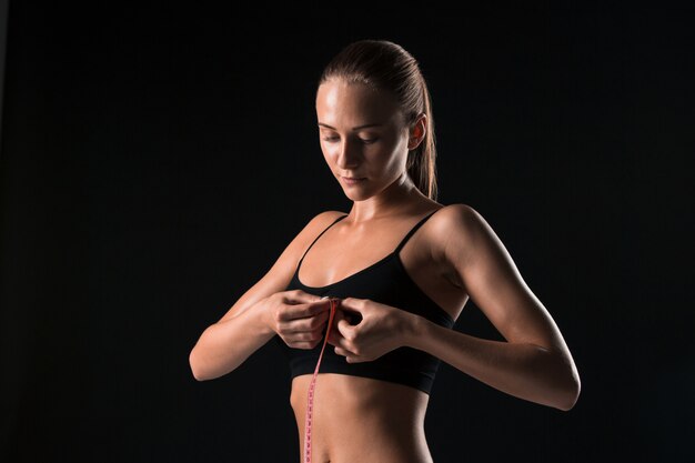 Fit mujer midiendo la forma perfecta del cuerpo hermoso