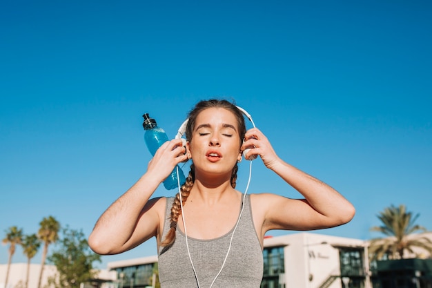 Foto gratuita fit mujer poniéndose auriculares