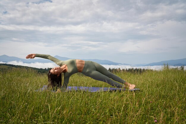 Fitness mujer disfrutando de la práctica de yoga entre la naturaleza
