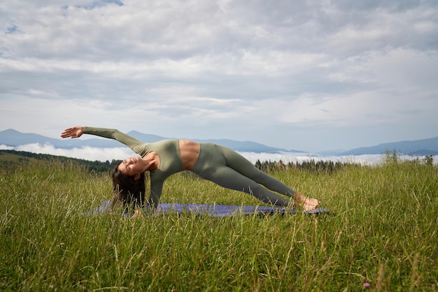 Fitness mujer disfrutando de la práctica de yoga entre la naturaleza