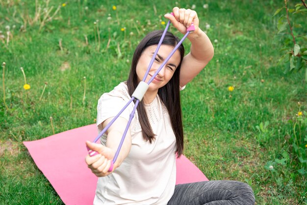 Foto gratuita fitness mujer haciendo ejercicio con banda de goma de fitness al aire libre