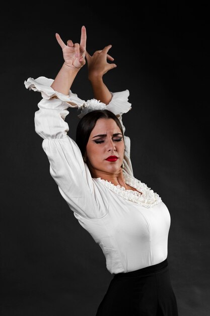 Flamenca con los brazos arriba sobre fondo negro