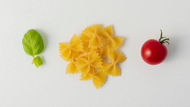 Flat lay sin cocer farfalle y tomate