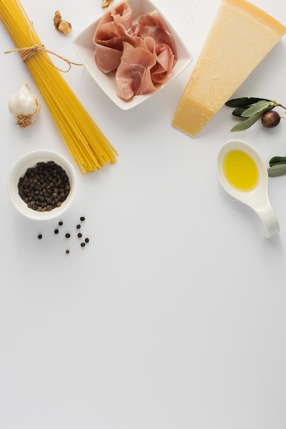 Foto gratuita flat lay sin cocer spaghetti prosciutto y parmesano con espacio de copia