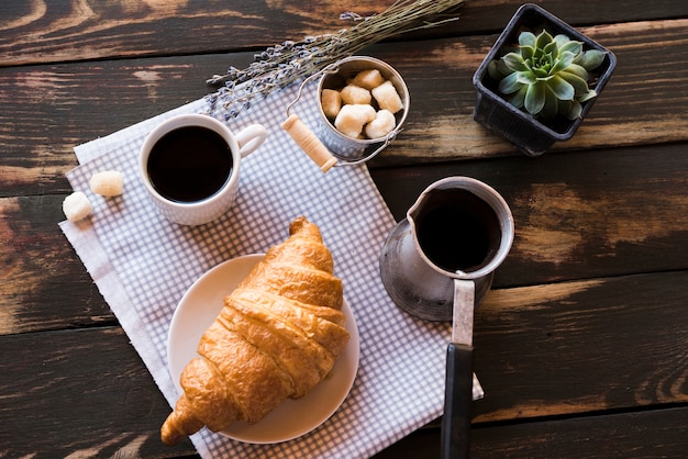 Flat lay delicioso café con croissant