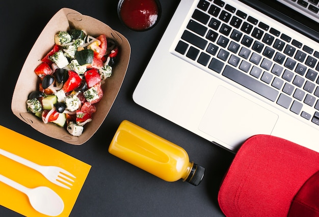 Flat lay food y laptop sobre fondo negro