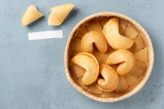 Flat lay fortune cookies en un tazón con nota en blanco