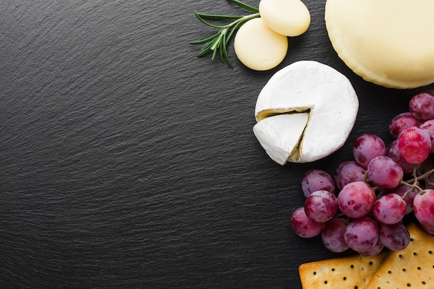 Flat lay gourmet camembert queso uvas y galletas con espacio de copia