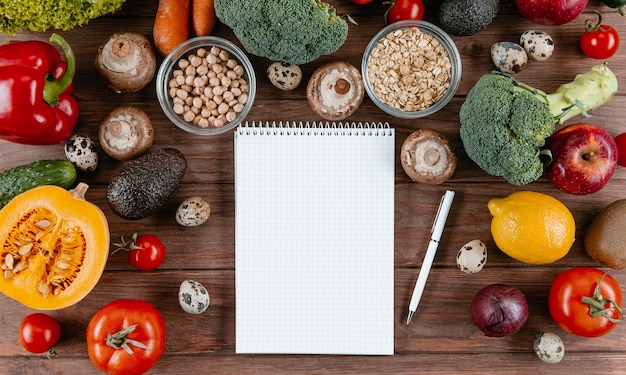 Flat lay of notebook con surtido de verduras