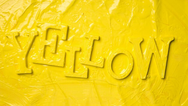 Flat lay de la palabra yellow con pintura