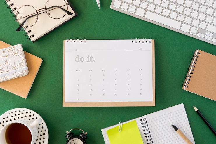 Photo Gratis flat lay planner calendar on green background