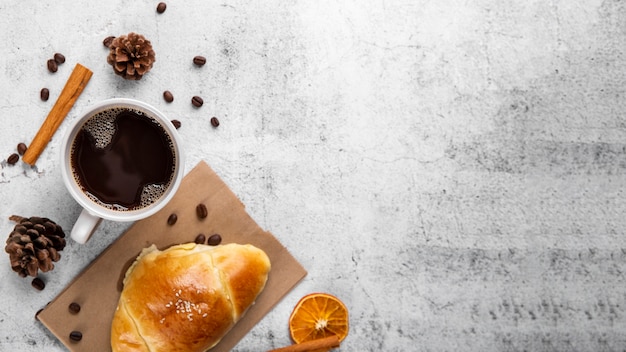 Flat lay taza de café y croissant con espacio de copia