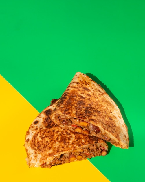 Flat lay tortilla crujiente pan sobre fondo verde y amarillo