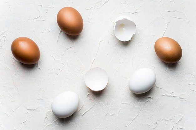 Flat pone huevos rotos sobre fondo blanco.