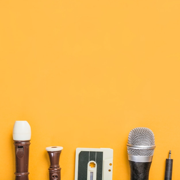 Flauta de bloque cinta de casete; micrófono sobre fondo amarillo