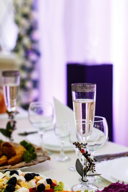 La flauta de champán decorada con ramas pequeñas se encuentra en la mesa