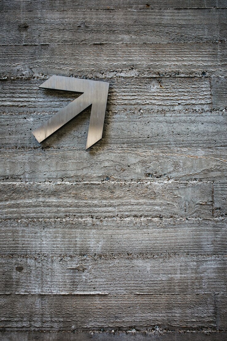 Foto gratuito flecha gris en la pared