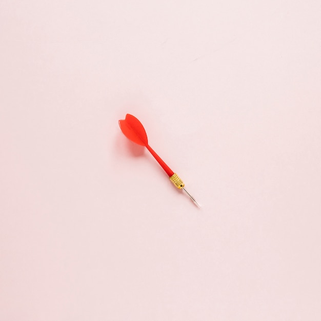Flecha plana de dardos sobre fondo rosa