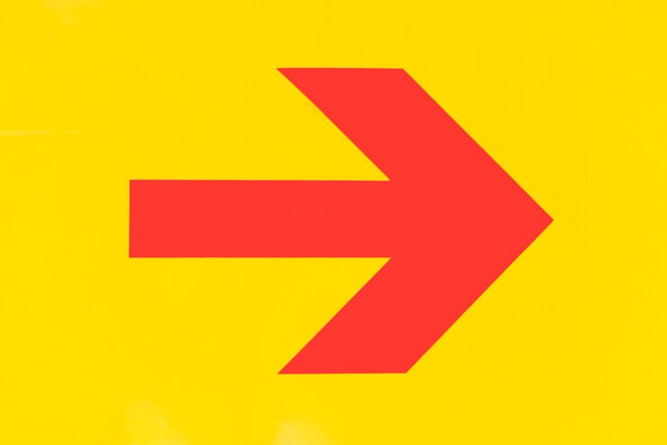 Foto gratuito flecha roja puntiaguda sobre fondo amarillo