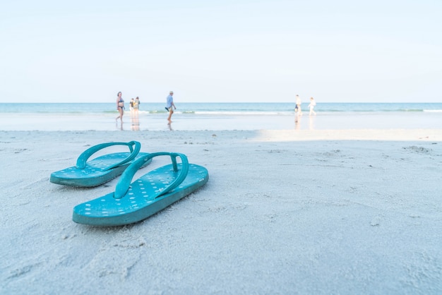 Flipflops en una playa de arena del océano