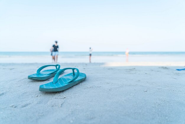 Flipflops en una playa de arena del océano