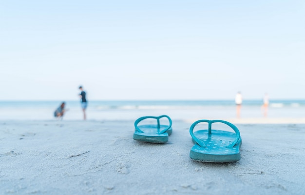 Flipflops en una playa de arena del océano