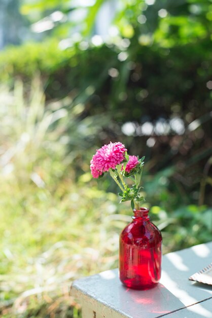 Flor decorativa en una botella roja