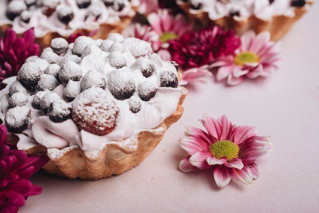 Flor fresca con tarta de bayas con crema batida.