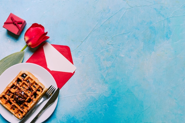 Foto gratuita flor, panadería en plato con cubiertos, caja de regalo y sobre