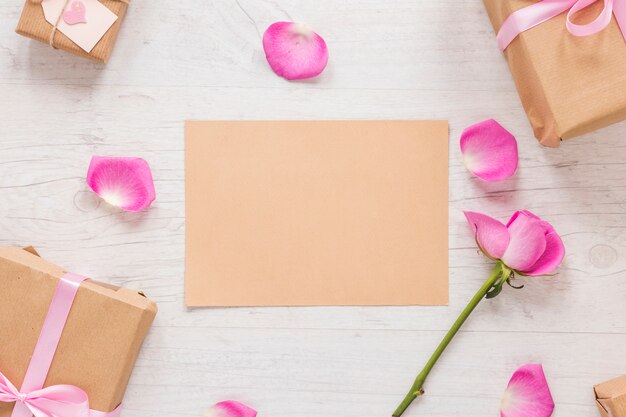 Flor rosa rosa con papel y cajas de regalo.