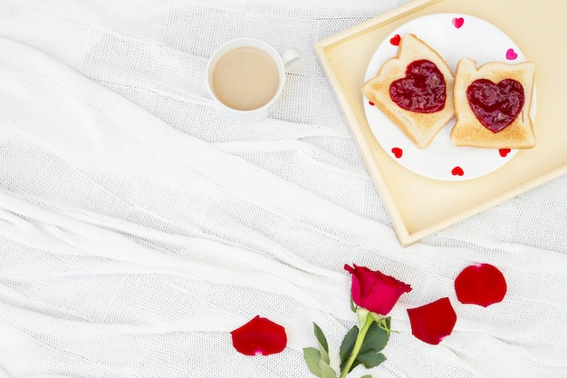 Foto gratuita flor de rosa y tostadas para el desayuno.