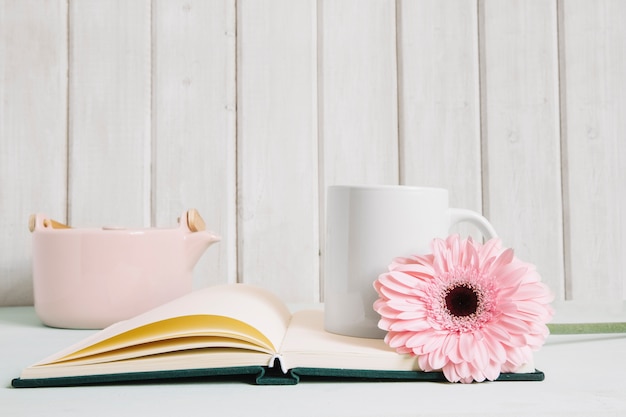 Flor y taza en el cuaderno abierto