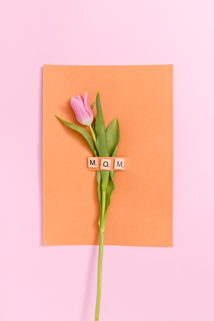 Foto gratuito flor de tulipán rosa sola; tarjeta naranja con bloque de texto mamá de madera sobre fondo de color