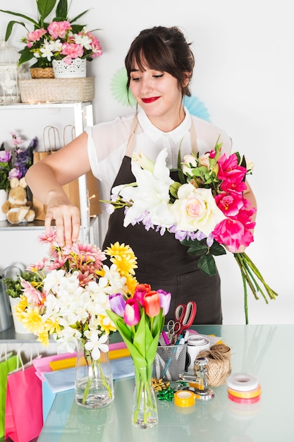 Floreria bonita mujer arreglando flores en florero