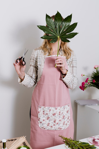 Foto gratuita floreria escondiéndose detrás de la hoja