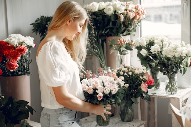 Floreria con flores. La mujer hace un ramo.