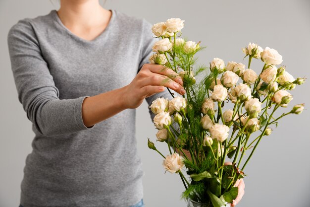 Floreria haciendo ramo de flores en florero