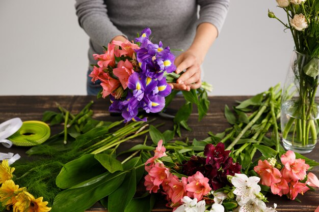 Floreria haciendo ramo de flores en florero