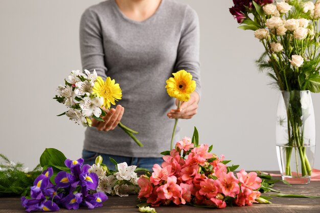 Floreria haciendo ramo de flores en florero