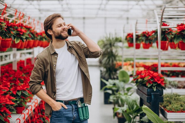 Foto gratuita floreria hombre trabajando en casa verde