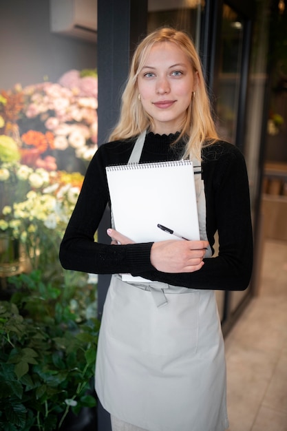 Floreria mujer sosteniendo un cuaderno