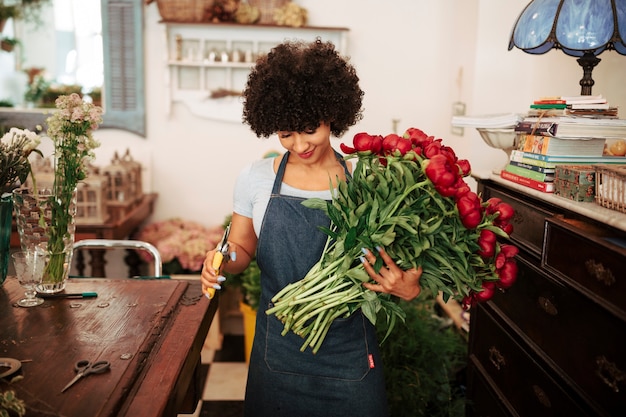 Foto gratuita floreria mujer sosteniendo ramo de flores rojas