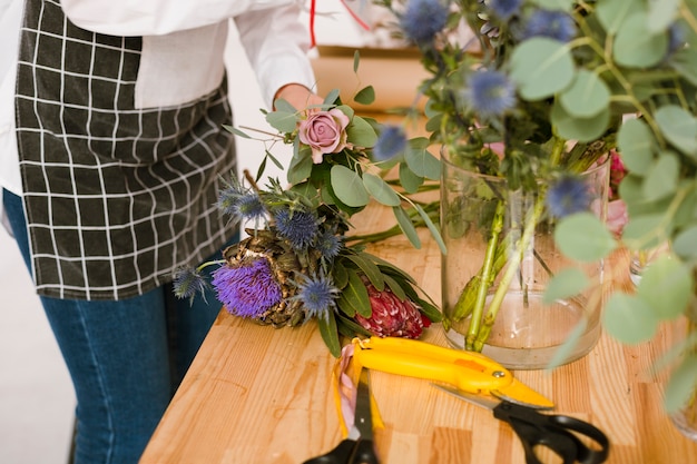 Floreria de primer plano trabajando en la tienda de flores