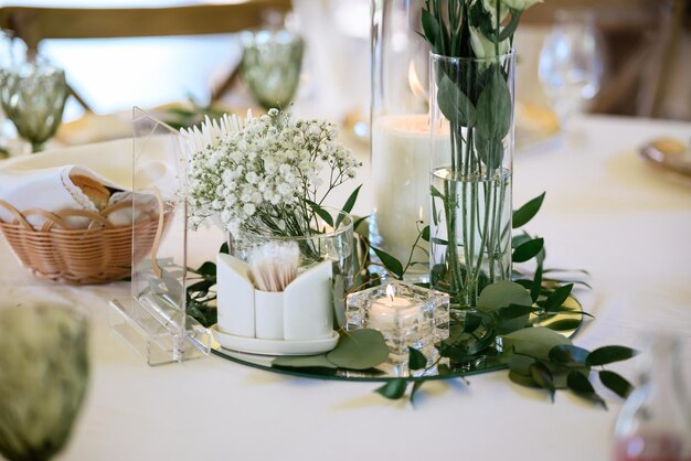 Florero de cristal con flores sobre una mesa blanca