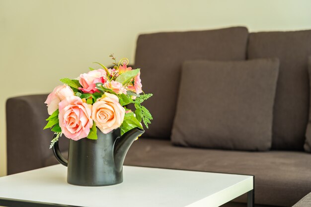 Florero de flores en la mesa con almohada y sofá decoración interior