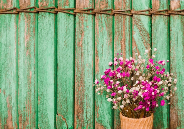 Flores de aliento rosa bebé contra fondo de persianas de madera